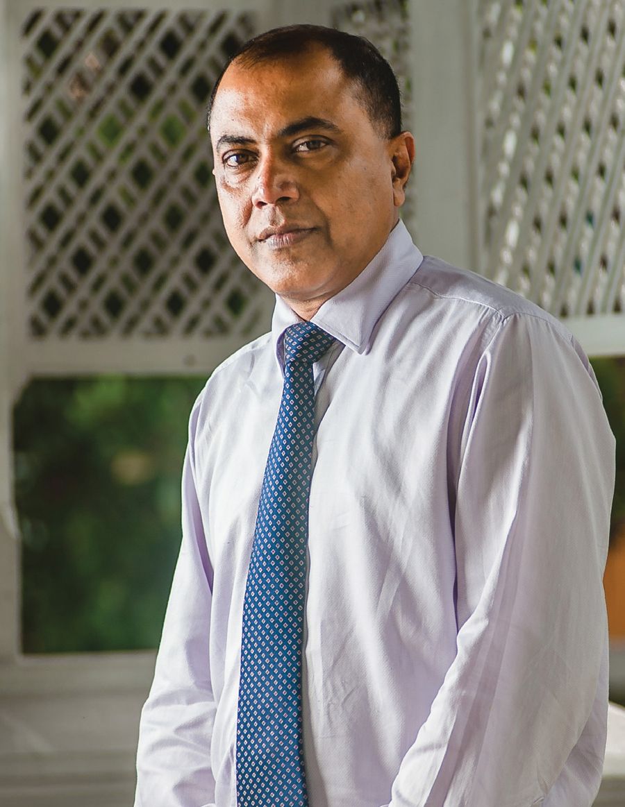 Dr. Kithsiri Edirisinghe in a shirt and tie