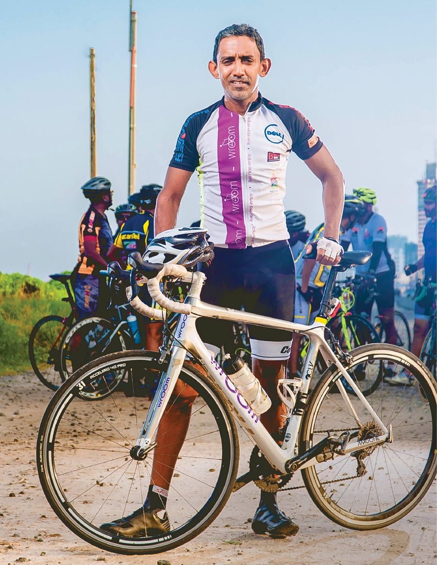 Yasas Hewage standing with his racing bike at dawn